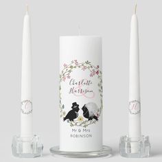 two white candles sitting next to each other on top of a glass stand with the words charlotte harrison and mr & mrs robinson