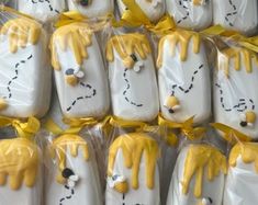 many decorated cookies are wrapped in plastic and have yellow icing on the top one