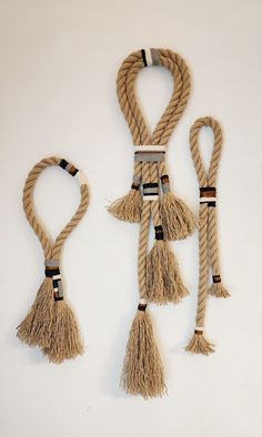 three pieces of rope with tassels hanging from them