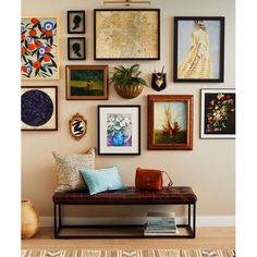 a wall filled with lots of framed pictures and art hanging on it's side