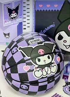 a purple and black ball sitting on top of a table next to notebooks with stickers