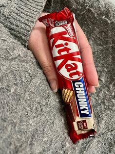 a person holding a candy bar in their hand