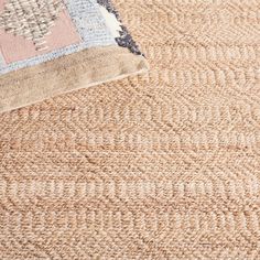 an area rug with a blue and pink design on the top, next to a beige carpet