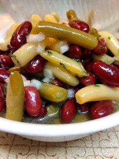 a white bowl filled with beans and pickles