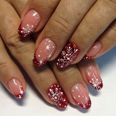 a woman's hands with red and white nail polishes on their nails, decorated with snowflakes