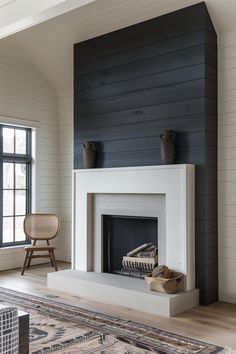 a living room with a fire place in the center and a rug on the floor