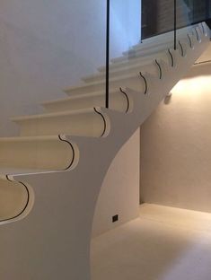 a white staircase with black handrails in a building