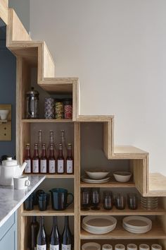 the shelves in this kitchen are filled with wine bottles and other things to drink from