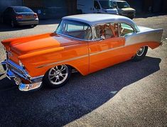 an orange and white car parked in a parking lot