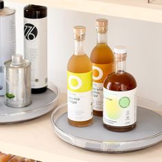 three bottles of alcohol sitting on top of a metal tray