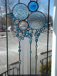 a close up of a stained glass window with beads and circles on the bottom part