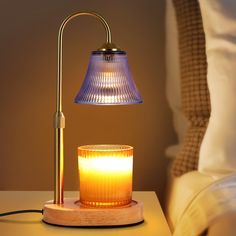 a table lamp with a lit candle next to it