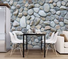 a living room with a table and chairs next to a wall made out of rocks