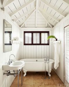 the bathroom is decorated in white and has an open roof, with exposed wood beams