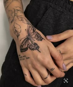 a woman's hand with a butterfly tattoo on it