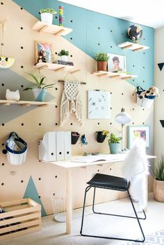 a room with shelves, plants and pictures on the wall