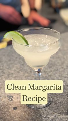 a margarita sitting on top of a counter with a lime wedge in the glass next to it