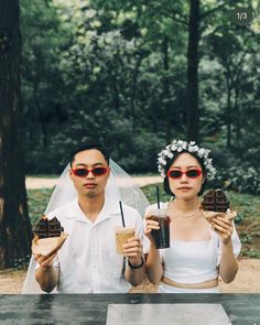 a man and woman sitting at a table holding drinks