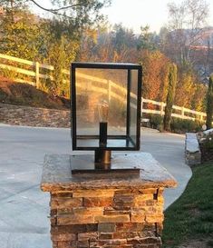 a lamp on top of a stone pillar