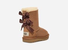 Your little one will adore these UGG® Toddlers' Bailey Bow II Boots with sweet silky bows in classic Brown. Designed for comfort and style, these boots feature a super-soft sheepskin lining and ultra-lightweight outsole for traction and durabilityâ€”perfect for active kiddos.The outsole of this product is either a SugarSole outsole, which is a responsible compound using sugarcane foam that allows us to reduce dependency on fossil fuels by replacing petroleum-based ethylene, or a Treadlite by UGG Toddler Uggs, Ugg Boots With Bows, Ugh Boots, Kids Ugg Boots, Baby Uggs, Bow Boots, Bailey Bow, Fossil Fuels, Classic Brown