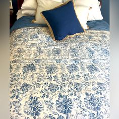 a blue and white bedspread with pillows on it