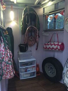 the inside of a camper with lots of storage and items hanging on the wall