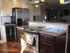 a kitchen with stainless steel appliances and wooden floors