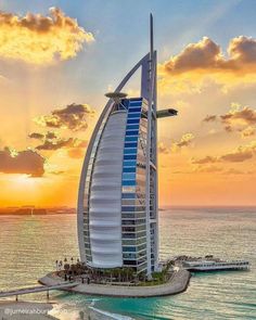 the burj building in dubai is lit up at sunset