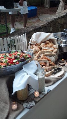 a table topped with lots of food next to a white fence