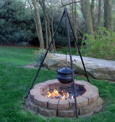 an outdoor fire pit in the middle of some grass