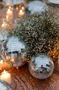 disco ball centerpieces with candles and baby's breath flowers on a table