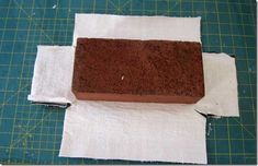 a block of chocolate cake sitting on top of a piece of paper