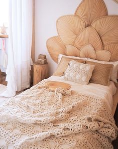 the bed is made up with white crocheted bedspreads and pillows