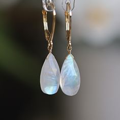 These Rainbow Moonstone Earrings feature breathtaking natural moonstones in a larger pear-cut shape in 14k Gold. Designed for those who adore statement earrings. Whether you are looking for a gift for a loved one born in June or simply treating yourself to a luxurious pair of earrings, these Dangle Moonstone Earrings are the perfect choice. MATERIALS: * 14k Gold (Yellow, Rose, White) * natural rainbow moonstone  * Leverback closure * beautiful branded gift box * card about moonstone SIZE: stones Moonstone Earrings Dangle, Moon Stone Earrings, Born In June, Daniel Fast, Earrings Teardrop, Rose Gold White, Moonstone Earrings, Box Card, Moonstone Necklace