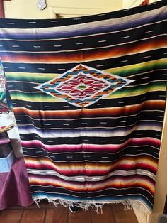 a multicolored blanket is hanging on the wall