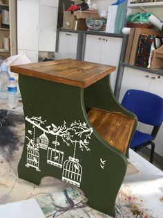 an old piano painted green with white birds on it