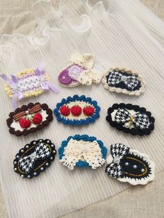 several crocheted hair clips are laid out on a white cloth covered tablecloth