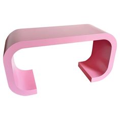 a pink shelf sitting on top of a white wall