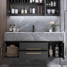 a bathroom with marble counter tops and shelves above the sink, along with other items