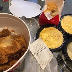 there are many different types of food in the bowl on the table, including fried chicken and macaroni and cheese