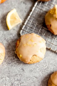 lemon cookies with icing on a cooling rack next to sliced lemons and orange slices