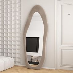 a mirror that is next to a wall with a monitor on it in the corner