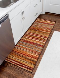 a kitchen area with sink, dishwasher and rug