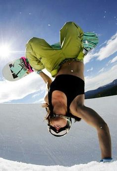 a snowboarder doing a trick in the air with his board on their feet