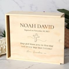 a wooden box with the words noah david printed on it and a cross in front