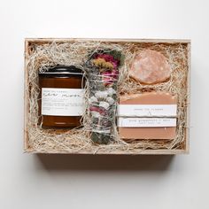 an open box containing soaps, honey, and other natural items in it on a white surface