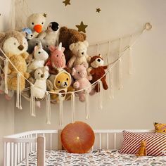 a crib with stuffed animals hanging from it's sides and stars on the wall