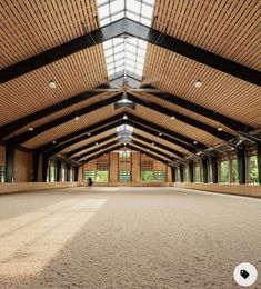 the inside of an indoor arena with lots of wood paneling and windows on the ceiling