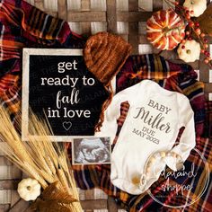 the baby announcement is laid out on a plaid blanket with pumpkins and other items