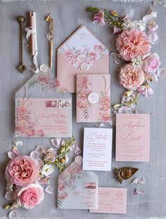 the wedding stationery is laid out with pink flowers